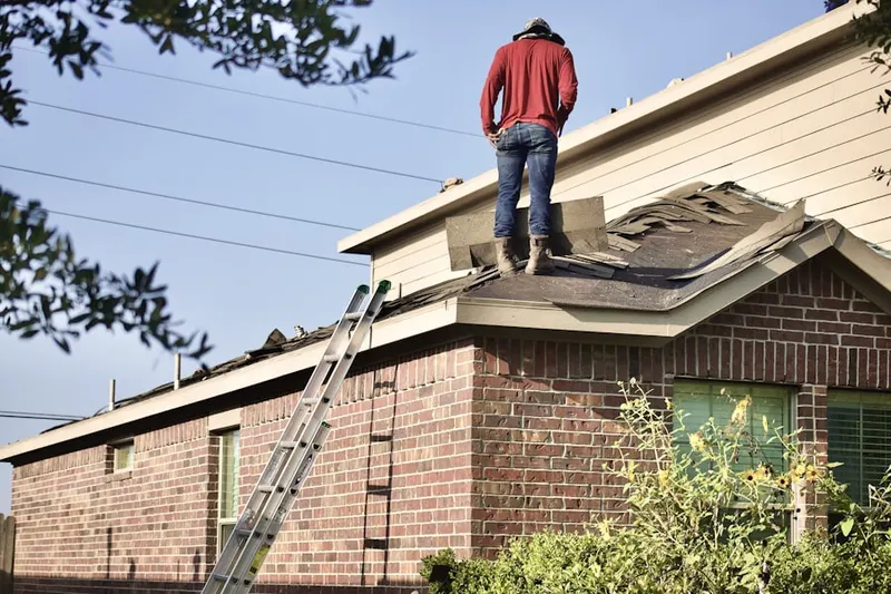 Professional roofer working on a residential roof in Delmar Estates